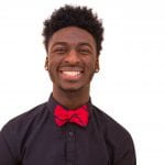 Headshot of Chiagoziem Ngwadom in a black shirt with red bow tie